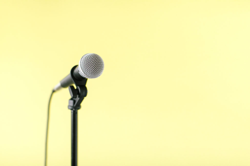 microphone on stand with a yellow background