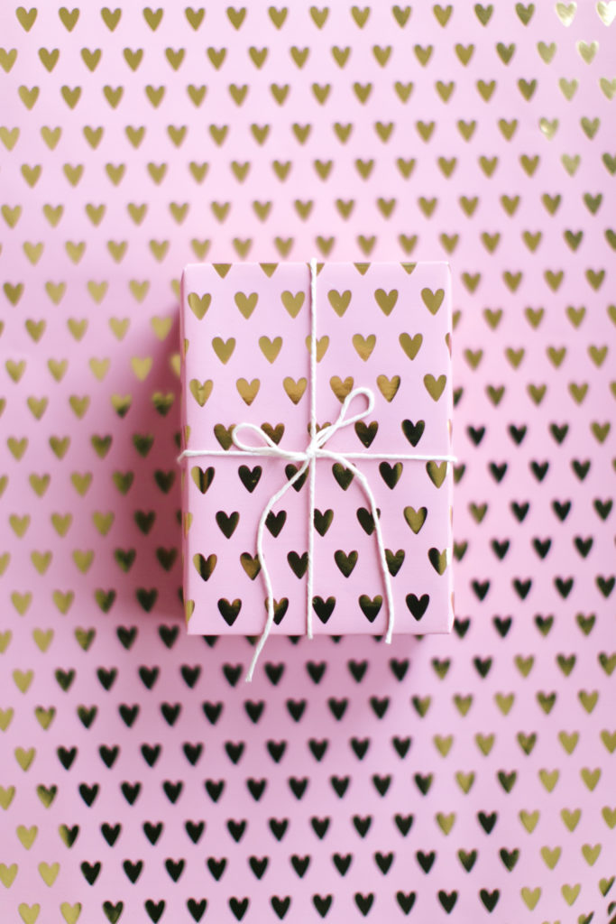 small box gift wrapped in pink paper with gold hearts