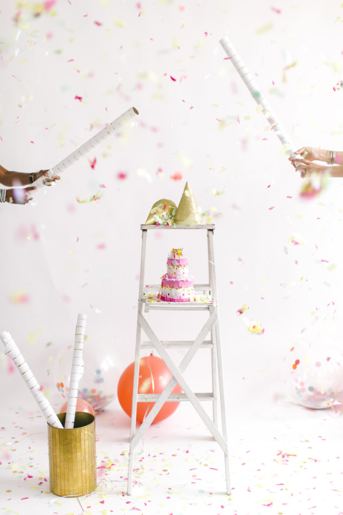 white ladder with party hats on top and paper cake with confetti flying celebrating low carb foods