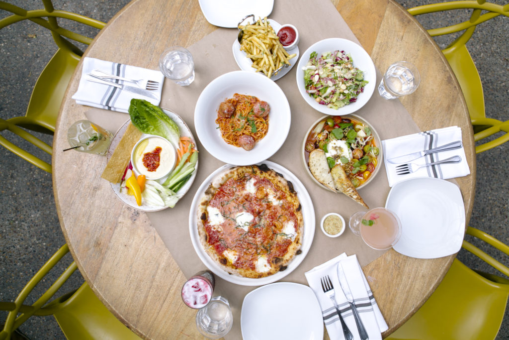 view from above of a round table with plated Italian food. Great gift for valentine's day on a budget